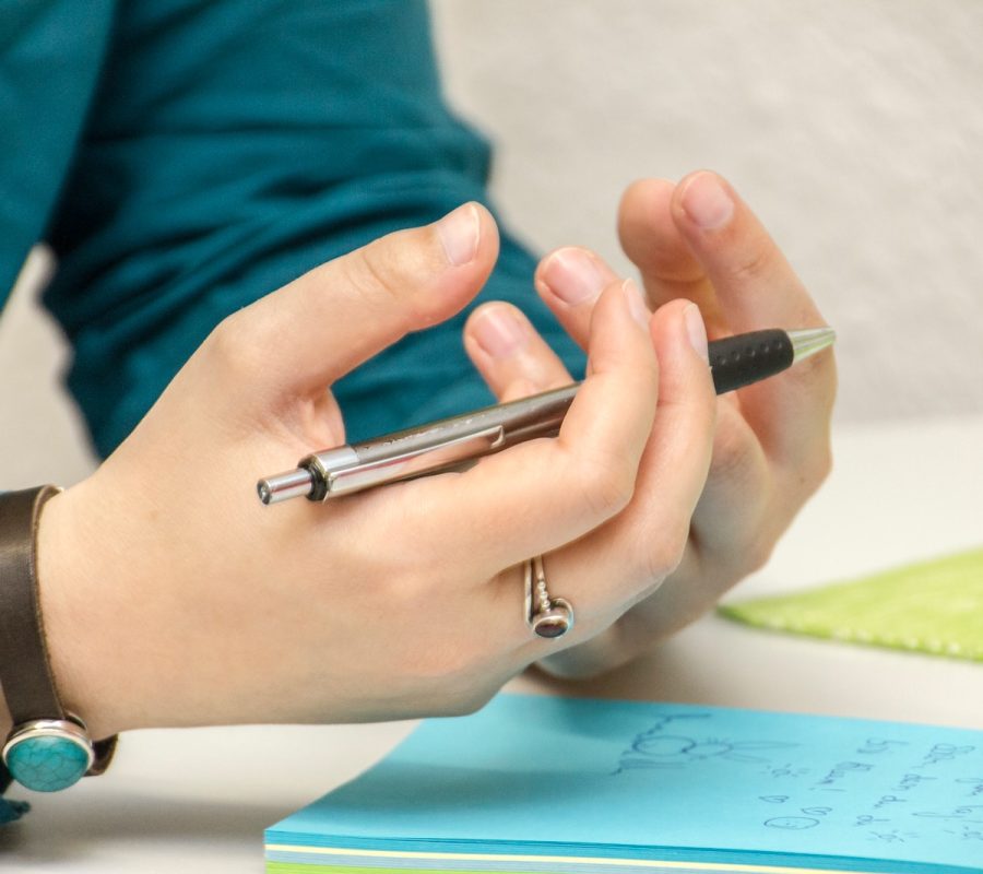 a person sitting at a table using a cell phone